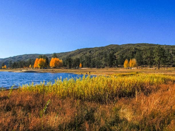 Inland Empire landscape with lake, fall foliage, and rolling hills